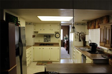 View of the kitchen from the family room and looking into the living room.  Kitchen is bright with stainless appliances that transfer.