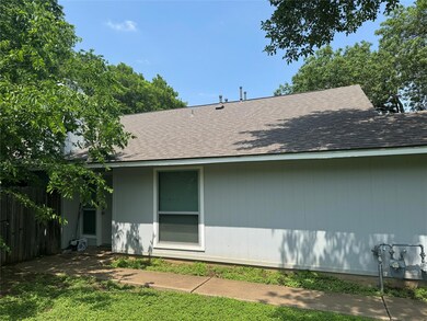 Back of property with fence and a shingled roof