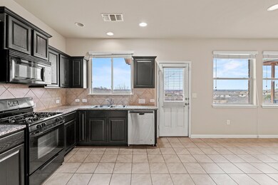 Kitchen with light tile patterned floors, a sink,