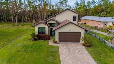 View of front of home with a front lawn, stucco siding, decorative driveway, and an attached garage