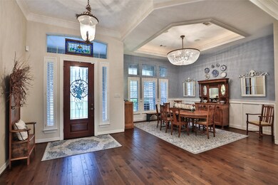 A view of the entry with transom windows that surround the front door. Beautiful hardwood floors, crown molding, and terrific entry light fixture! The Formal Dining Room is situated to the right in the picture!