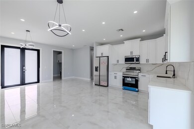 Kitchen with stainless steel appliances, a chandel