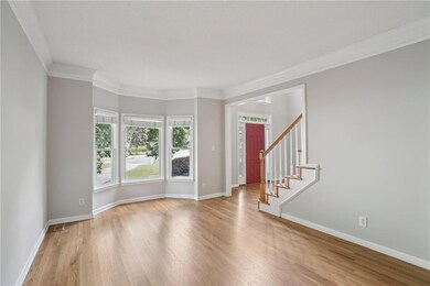 Entryway with wood finished floors, baseboards, crown molding, and stairs