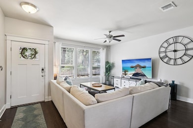 Living area featuring dark wood-style floors and a ceiling fan