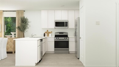 Kitchen with white cabinetry, sink, kitchen penins