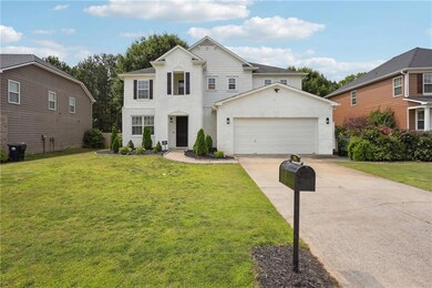 Traditional home with driveway, a front yard, and a garage