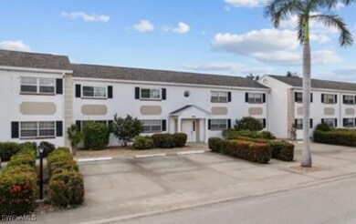 View of building exterior featuring uncovered parking for residents and guests