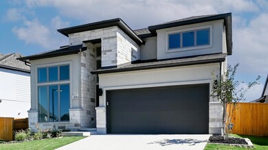 View of front of property with stone siding, an attached garage, driveway, and stucco siding