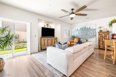 Living room with wood finished floors and a ceiling fan