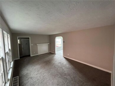 Spare room with a textured ceiling and dark carpet