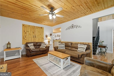 Upgraded living room featuring hardwoods, wood-burning gin fireplace, and stunning wood ceiling to accentuate the balance between rustic and craftsman charm.