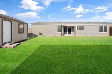 She shed or man cave to the left, back of home straight ahead.  This area is fenced in for pets or a play yard for kids.