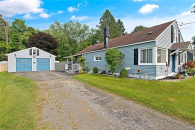 View of driveway side of home and 2 car garage wit