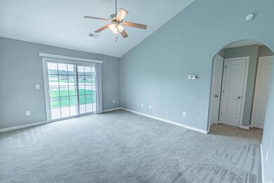 Carpeted empty room featuring high vaulted ceiling