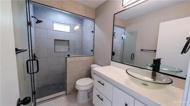 Full bathroom with toilet, a shower stall, and vanity