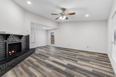 Living room with a brick fireplace, wood-type floo