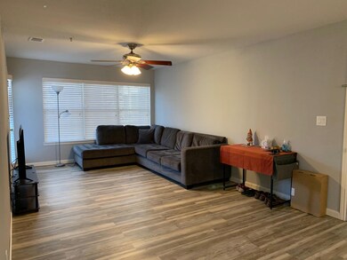 Living room with a ceiling fan, wood finished flo