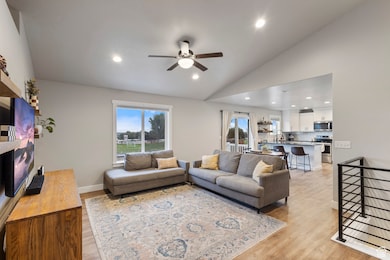 Living room with lofted ceiling, recessed lighting, light wood-style floors, and ceiling fan