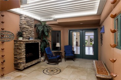 View of exterior entry with french doors, a firepl