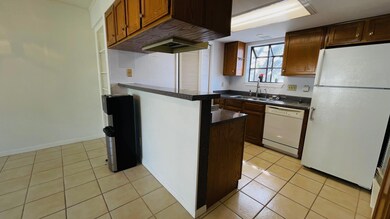 Kitchen featuring light tile patterned flooring and white appliances