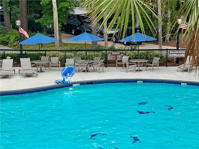 Pool area, tables, lounge chairs, umbrellas, water