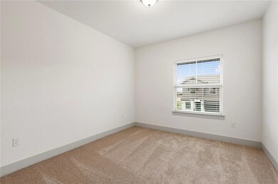 Empty room featuring light colored carpet and bas