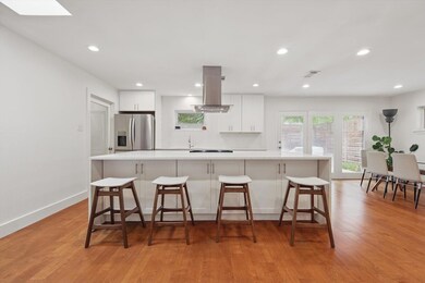 Kitchen featuring island range hood, light wood-st