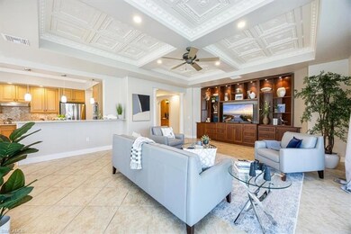 Tiled living room featuring ceiling fan, coffered 