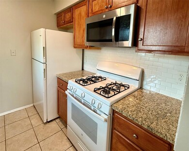 Kitchen featuring white appliances, brown cabinet