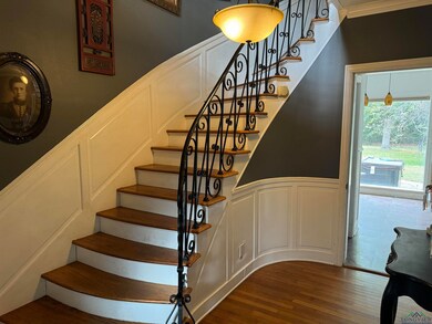 Stairway featuring crown molding and wood-type flo