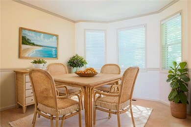 Dining space with light colored carpet, crown molding, and baseboards