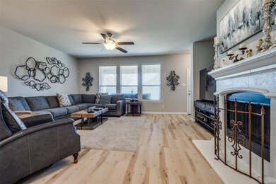 Living area featuring baseboards, a fireplace, lig