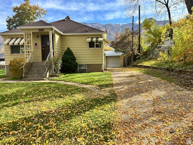 View of front of property with a mountain view, a chimney, a shingled roof, and a garage