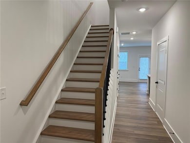 Stairs featuring wood finished floors, baseboards, and recessed lighting