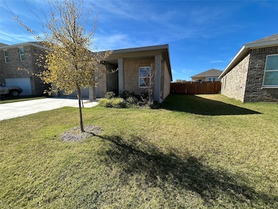 View of front facade featuring driveway and brick siding