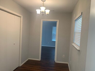 Unfurnished dining area with dark wood-style flooring and a chandelier