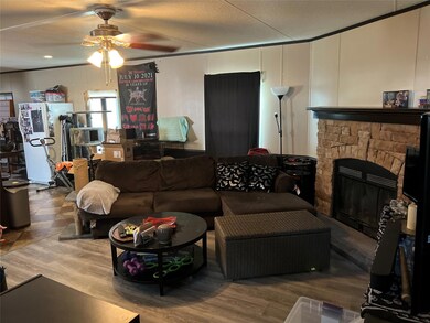 Living room featuring ceiling fan, a decorative w