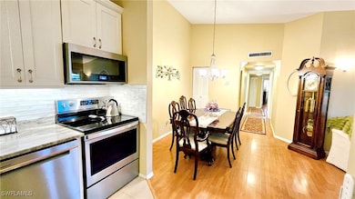 Kitchen with tasteful backsplash, light wood-type