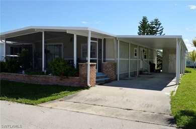 Manufactured / mobile home featuring a carport and a front lawn