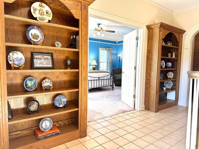 Hall featuring ornamental molding and light tile p