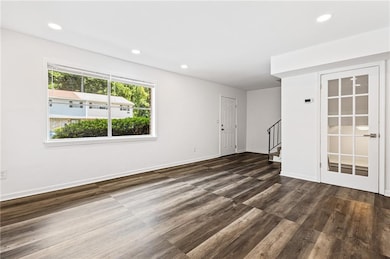 Unfurnished living room featuring recessed lighting, stairway, and dark wood-style floors