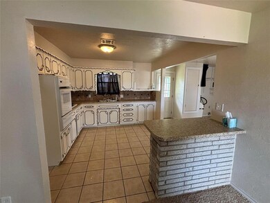 Kitchen featuring sink, decorative backsplash, whi
