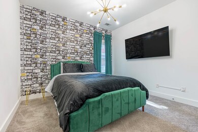 Bedroom featuring light carpet, baseboards, visibl