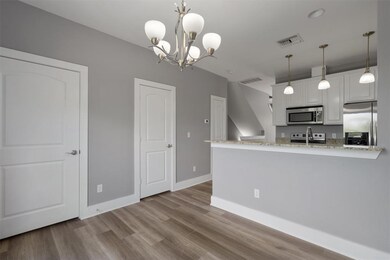 Kitchen with stainless steel appliances, wood fin