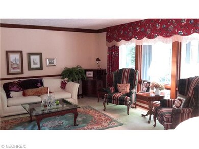 LIVING ROOM WITH HUGE PELLA WINDOWS LOOKING OUT OVER PATIO AND WOODED BACKYARD