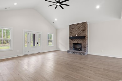 Unfurnished living room featuring ceiling fan, a f