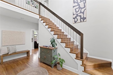 Warm and inviting two stroy foyer, note updated stair rail