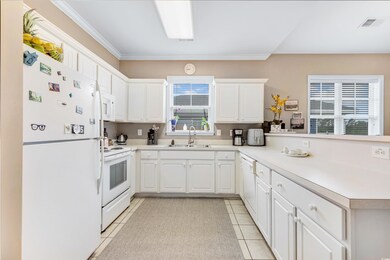 Kitchen with white cabinetry, light tile patterned
