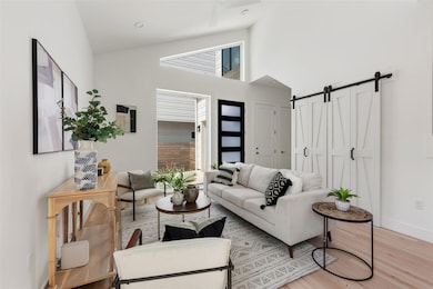 Living area with light wood-style flooring, a bar