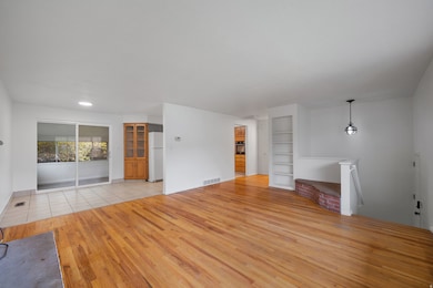 Unfurnished living room featuring light wood-style floors and built in shelves